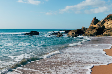 Ocean seasade with waves, sand and rocks 