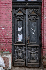 old wooden door in old town. Antique wooden black door and architectural details of dilapidated...