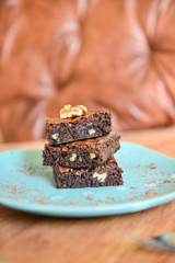 BROWNIES.A stack of chocolate brownies on a plate with wooden background homemade bakery and...