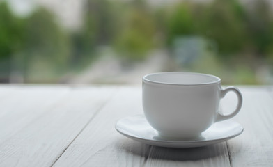White porcelain cup on white wooden background
