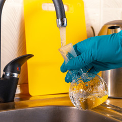 water purification specialist tap water pours into a glass flask.