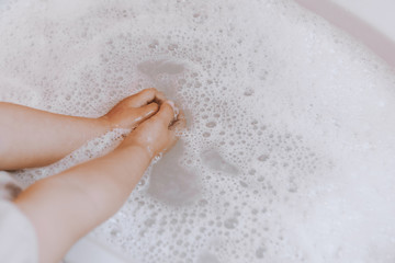 Cute little toddler girl washing her hands in a bathroom. Hygiene concept showing prevention of infection and viruses such as flu and covid-19