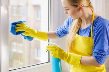 Woman cleaning window at home