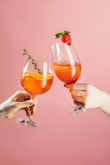 cocktail on pink background with strawberry and rosemary