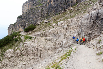 Obraz premium People hiking in Brenta Dolomites mountains during rain, Italy