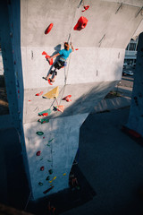 The girl climbs the climbing wall at competitions