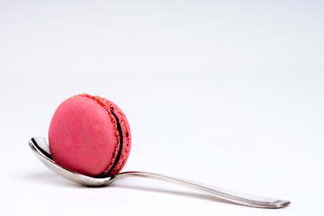 Macarons de couleurs avec petite cuillère sur fond blance