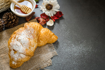 Fresh croissant with almond on a black slate background. Top view . Copy space