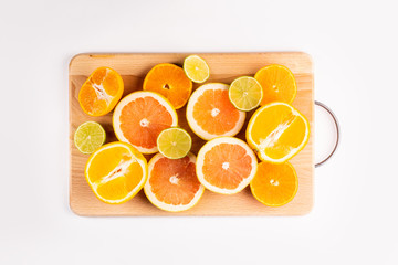 Sliced citrus fruits on a wooden board on a white background. Vitamin C is for your health