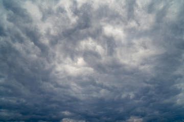 dark grey cloudy sky with epic clouds above city. 