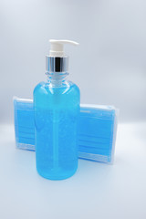 Blue medical face mask with alcohol sanitizer gel hand wash on white background for covid-19 Coronavirus prevention concept. Front of view medical mask and sanitizer gel.