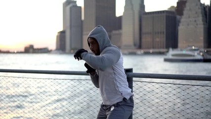 Concept of determinate for sport goals for getting to triumph and win, slow motion effect of Latin male bodybuilder in hood training strong of own punch practicing fight power
