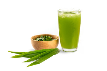 Fresh Pandan juice in glass with leaves and sliced in wooden bowl on white background.

