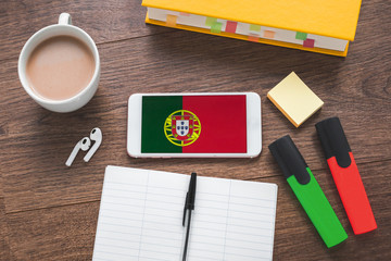 flatlay online learning a foreign Portuguese language, cup of coffee, notebook, pen, textbook,...