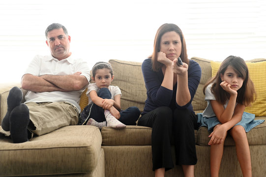 Bored family staring at TV screen