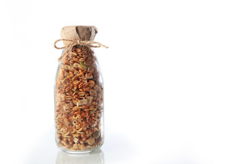 One glass bottle of granola or granola on a white background. An isolated object. Copy of the...