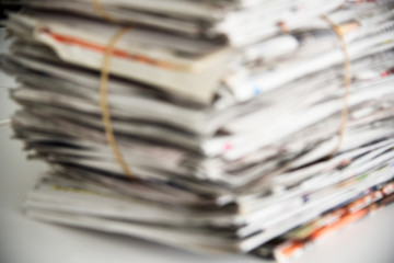 Blurred a pile of newspaper, background texture. Lots of retro journals with headlines, articles and photos