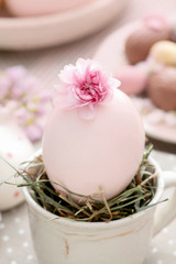 Easter egg in ceramic cup. Simple table decoration.