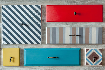 multi-colored wooden drawers with handles in the wall
