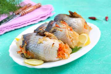 Baked herring stuffed with vegetables. Tasty fish rolls.