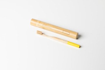 Wooden toothbrush with wooden box made of bamboo on white background.