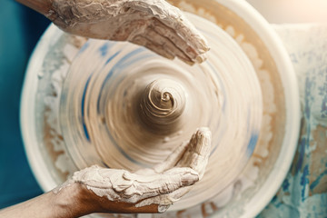 Close-up of female hands sculpting clay on a Potter's wheel. Concept of hobby and cretivity at home and in the Studio workshop - obrazy, fototapety, plakaty