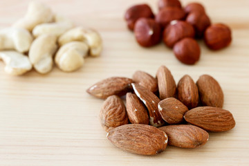 Almonds and nuts on wooden table. 