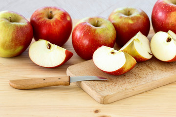 Red and yellow apples on wooden table.
