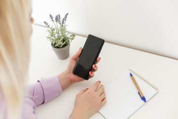 beautiful young woman using an application to send an sms message in her smartphone device while eating a salad