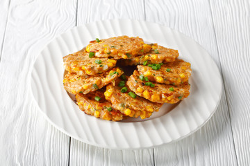 cheese and corn pancakes on a plate, top view