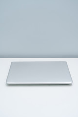 Silver gray laptop placed on white desk