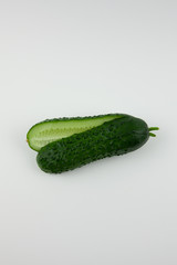 Green cut cucumber on a white background. For making a delicious salad.