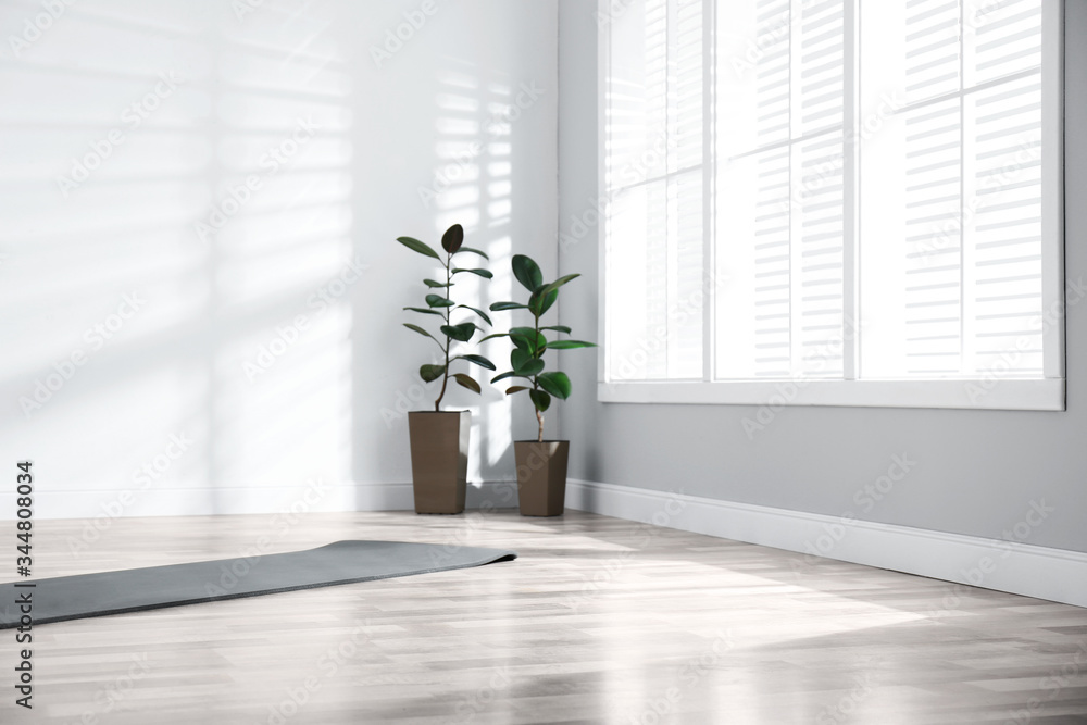 Poster Unrolled grey yoga mat on floor in room