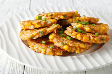 cheese and corn pancakes on a plate, top view