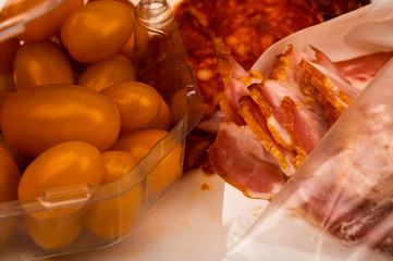 Slices of sausage and bacon and tomatoes on a white background. Close up.