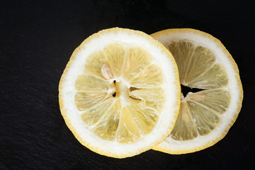 round slices of lemon on a black background
