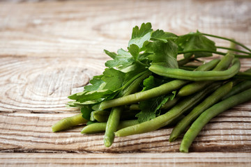 green beans and parsley on a wooden background