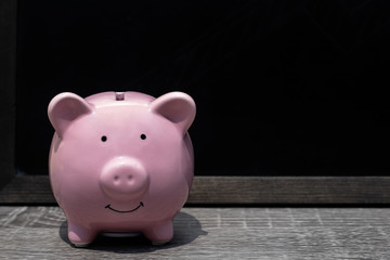 Pink piggy bank with black background, Protect savings, Protect capital, Protect retirement fund concept