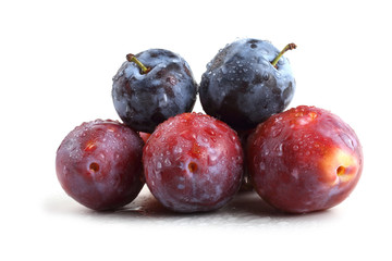 Red and black plums isolated on white