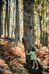 Naklejka premium Little girl in an autumn forest among ferns