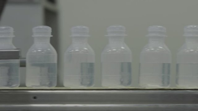 plastic bottles on Medical Solutions Conveyor . Blow fill seal technology technique used to produce liquid-filled container on medical or food industrial factory. close up medical industry