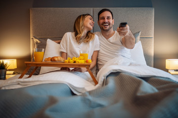 Couple watching tv in bedroom