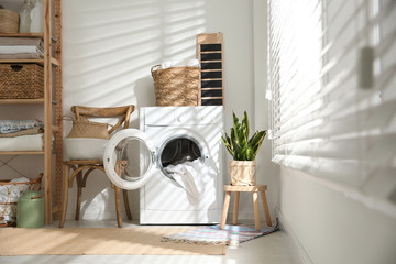 Modern washing machine in laundry room interior - obrazy, fototapety, plakaty