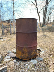 Fototapeta premium one old ugly rain barrel for catching roof water for the garden and a rotating composter off