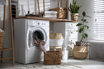 Stylish bathroom interior with modern washing machine