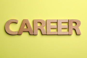 Word CAREER made with wooden letters on yellow background, flat lay