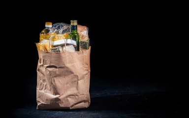 Paper bag with products on a dark background. Food donations