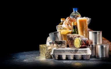 Food donations of different products on dark background, top view with copy space