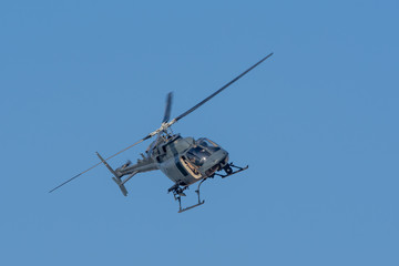Fototapeta na wymiar Military chopper in war flies on angle through the sky. Military concept of power, force, strength, air raid.