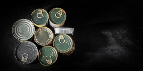 Tin cans with food on dark background